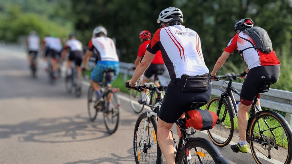 Eine Gruppe Radfahrer mit Tourenrädern fahren auf einer Straße.
